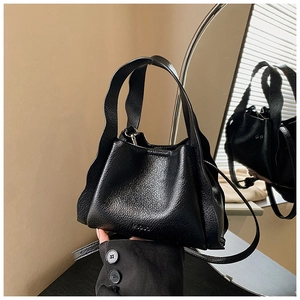 Detail of black pebbled leather bucket bag with wavy handle and MUOLO embossed logo