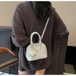 Vista dettagliata di una borsa a mano a forma di conchiglia con ciondolo a cuore
