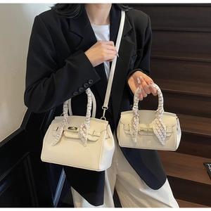 Detail of cream lychee leather handbags with silk scarf handle and golden lock hardware