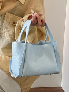 Minimalist light blue leather bucket bag with wave pleated design and top handle