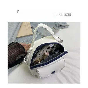 Détail du sac bandoulière en cuir PU blanc montrant l'intérieur organisé avec maquillage