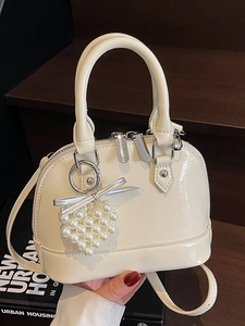 Elegante borsa a mano a conchiglia in vernice bianco crema con ciondolo a cuore
