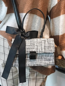 Chic black and white checkered tweed crossbody bag with elegant satin bow and metal clasp