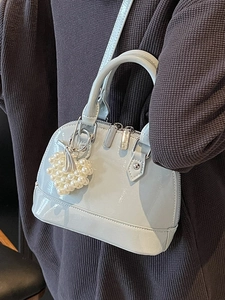 Borsa a conchiglia celeste in pelle verniciata lucida con ciondolo cuore di perla e tracolla