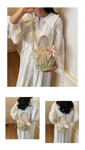 Detail showing handcrafted straw bucket bag with green hello embroidery and floral ribbon