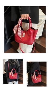 Detail of red crocodile pattern bucket bag with decorative silk scarf and metal lock