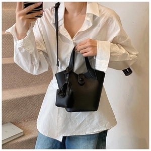 Close-up of a black lychee-grain leather bucket bag with an extra small pouch accessory