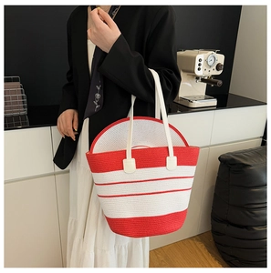 Détail d'un sac cabas tissé à rayures rouges et blanches avec chapeau de plage assorti