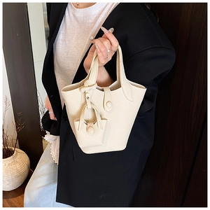 Detail of lychee pattern leather handbag with matching mini bag charm in cream white