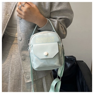 Détail du sac de téléphone bleu clair avec imprimé STORY et bandoulière réglable