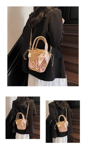 Detail of straw bucket bag featuring pink Hello embroidery and floral accent decoration