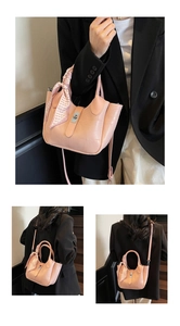 Detail of pink croc-embossed bucket bag with decorative silk scarf and metal lock