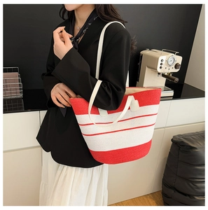 Détail d'un sac cabas tissé à rayures rouges et blanches avec poignées en cuir PU blanc