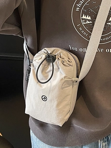 Minimalist light gray drawstring crossbody bag with sporty nylon texture for women