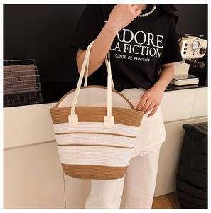 Détail d'un grand sac de plage tissé à rayures marron et blanc avec poignées en similicuir