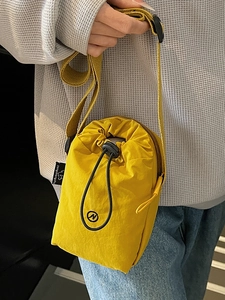 Bright yellow nylon crossbody bag with drawstring design for casual sports and travel use