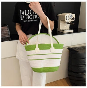 Détail du sac de plage tissé à rayures vertes et blanches avec anses en cuir et chapeau