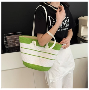 Détail du sac de plage tissé vert et blanc avec lanières en cuir et doublure en tissu