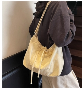Minimalist cream canvas tote bag detail showing large capacity and drawstrings on a model