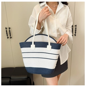 Détail du sac de plage tissé avec rayures bleu marine et blanc et coutures renforcées
