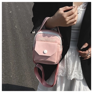 Sac à bandoulière rose sport avec imprimé STORY porté par un mannequin dans la rue