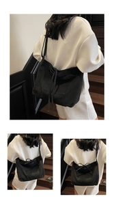 Detail view of black canvas tote bag with drawstring features and spacious outer pockets