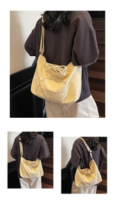 Detail view of the cream canvas tote bag showing adjustable straps and front pocket