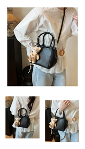 Détail du sac seau noir en cuir avec pendentif ours mignon et poignée ronde chic