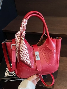 Fashionable red bucket bag with crocodile texture, silver metal lock, and scarf handle