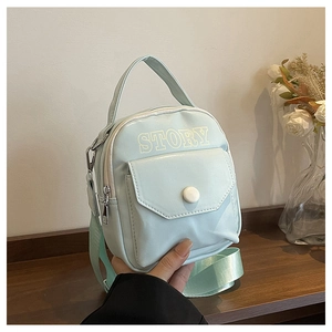 Détail du mini sac bandoulière vert menthe avec inscription STORY et sangle réglable