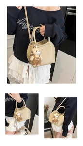 Détail du sac seau en cuir beige grainé avec un joli pendentif ours en peluche