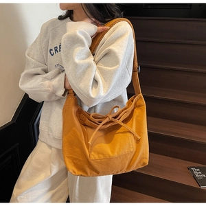 Detail view of the large canvas tote bag with decorative bow and large front pocket