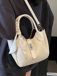 Chic cream bucket bag with crocodile texture, metal twist lock and decorative silk scarf