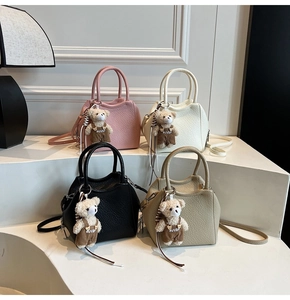 Détail de quatre sacs seaux élégants en cuir grainé rose, blanc, noir et couleur kaki