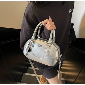 Détails de ce sac Boston argenté avec logo embossé et pendentif cadenas en gros plan