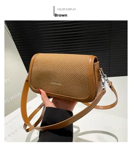 Detail of brown faux leather shoulder bag featuring woven texture and fashion logo