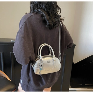 Vue détaillée du sac Boston argenté avec fini métallisé et logo embossé sur le cuir