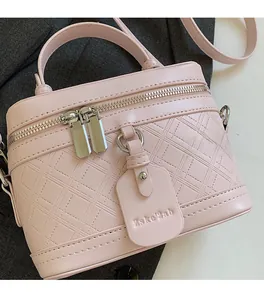 Close-up of pink quilted box bag with silver zippers and elegant faux leather texture