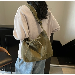 Detail view of large canvas tote bag showing the front pocket and drawstring closure
