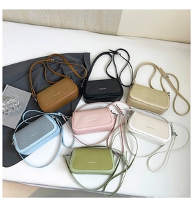 Flat lay of colorful minimalist crossbody bags with woven texture and long shoulder straps