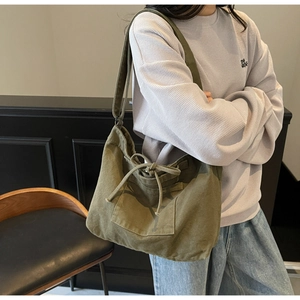 Detail of olive green canvas tote bag showing the drawstring closure and adjustable strap