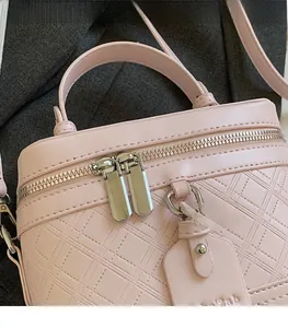 Close-up of pink quilted box bag showing silver double zippers and fine leather texture