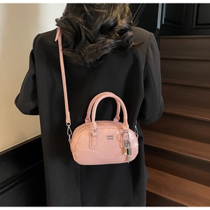 Sac Boston rose sur mannequin avec lettres métalliques et détail de cadenas en intérieur