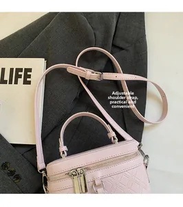 Detail view of pink quilted bucket bag with adjustable leather strap and double zipper closure