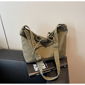 Detail of army green canvas hobo bag with adjustable strap and decorative bow knot