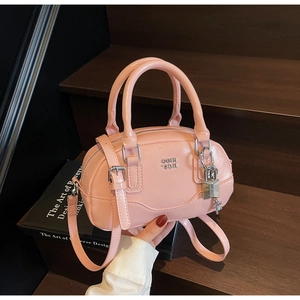 Détail du mini sac Boston en cuir verni rose avec logo en métal et breloque cadenas argenté