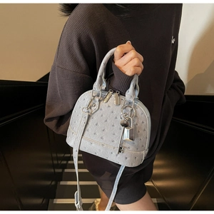 Dettaglio borsa a conchiglia azzurra goffrata struzzo con hardware argento e lucchetto