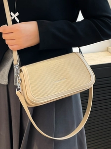 Chic beige crossbody bag with textured flap and silver hardware for modern women