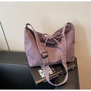 Detail of purple washed canvas tote bag with bow drawstring and adjustable strap