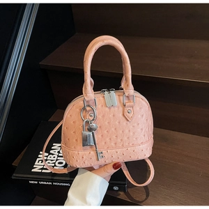 Dettaglio mini borsa a cupola rosa testurizzata struzzo con lucchetto e chiave in argento